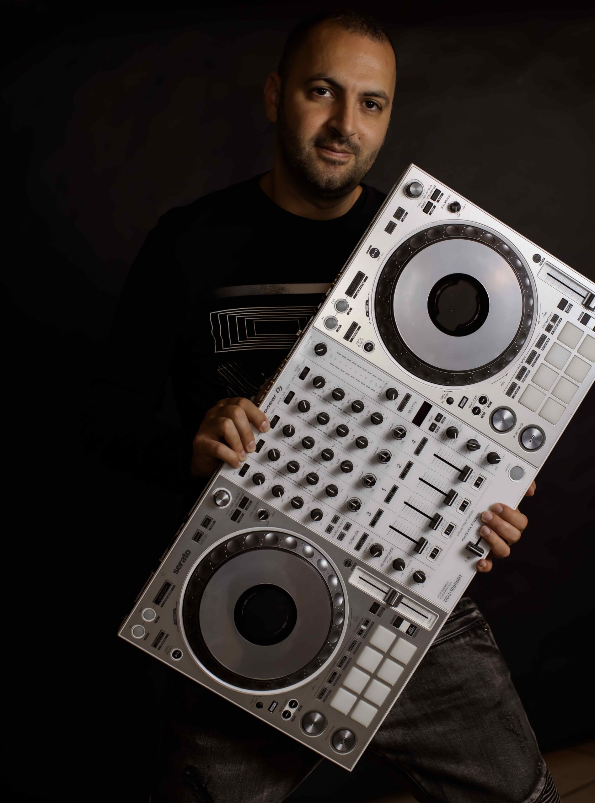 DJ holding a professional DJ controller, showcasing audio equipment relevant for, best dj for church events and ceremonies.